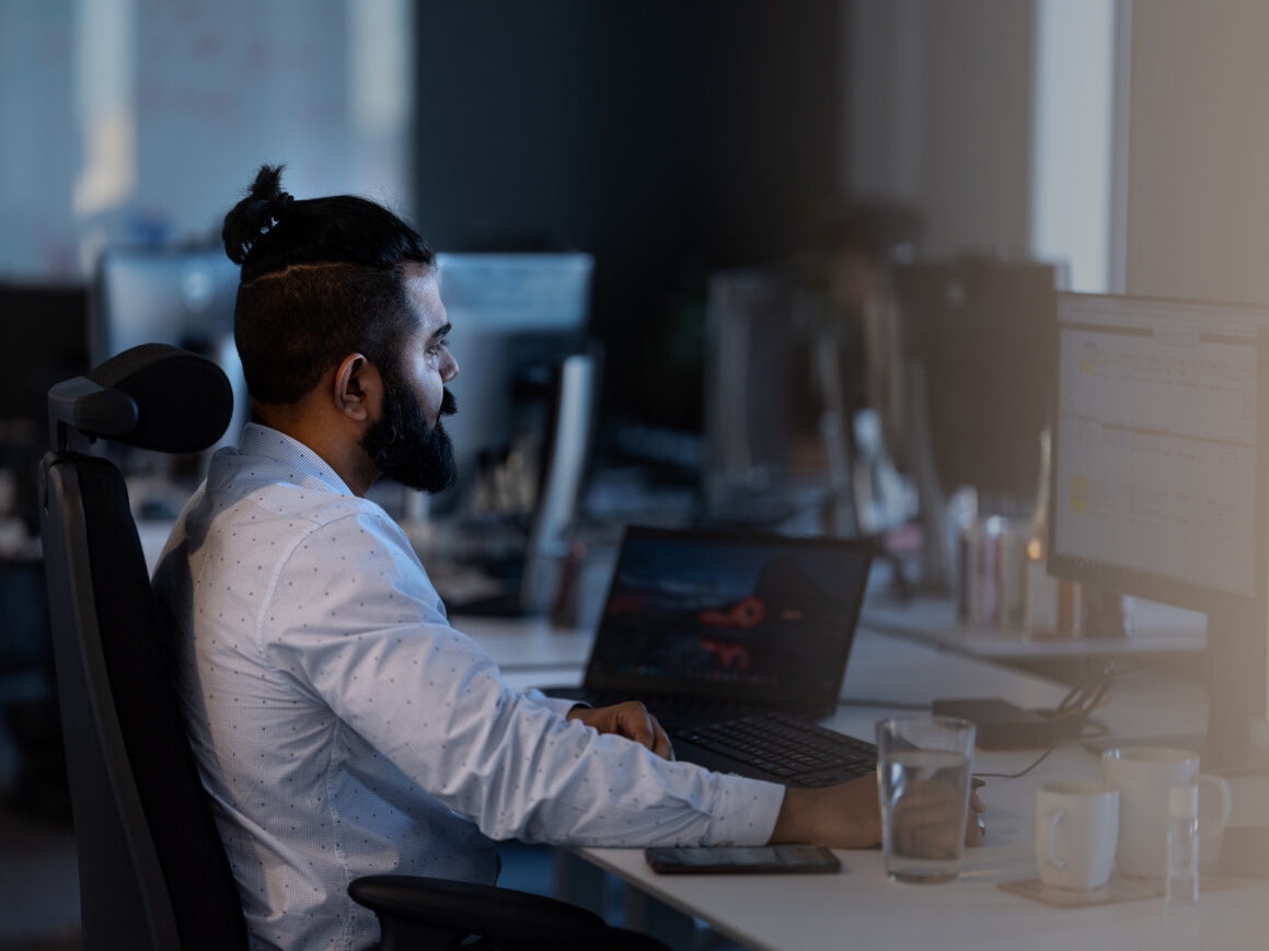 A man sitting in a modern office setting and working.