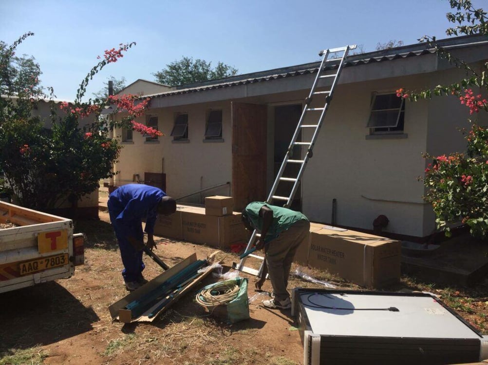 Two men working on electricity cables in the yard of Fatima Clinic.