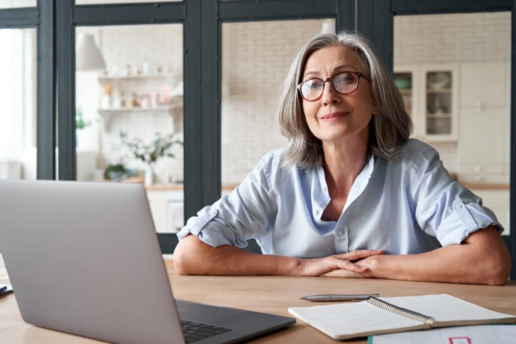 A woman with glasses is engaged in work at her desk,