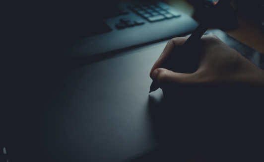 Close-up of a hand with a pen, symbolizing traditional signatures in the context of an article about e-signatures